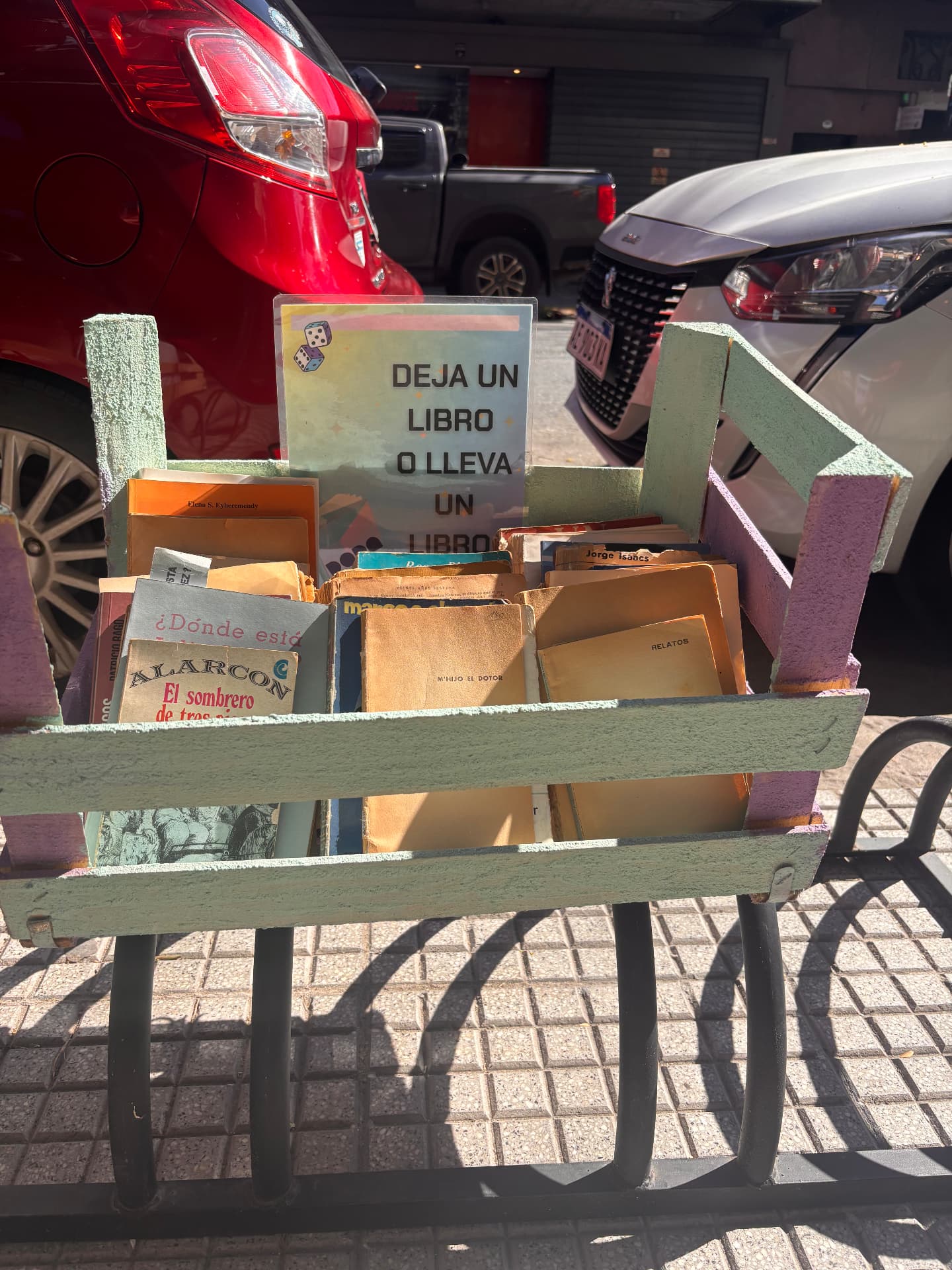 Wooden crate of second hand books on a Buenos Aires pavement with a sign reading leave a book or take a book
